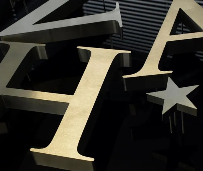 Nowoczesne metalowe litery podświetlane LED na czarnym tle - przykład profesjonalnego oznakowania reklamowego